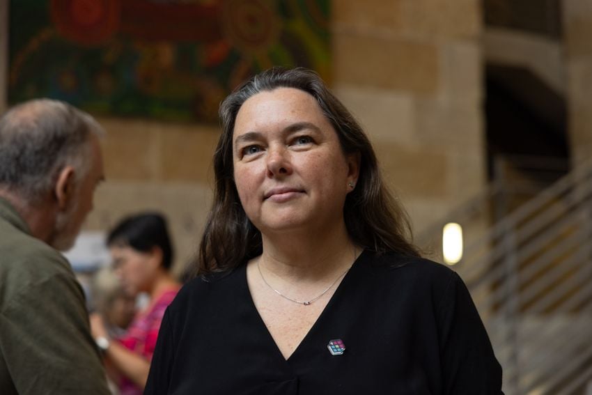 Felicity Maxwell, a board member of Aura, poses for a photo prior to the Austin city council meeting on Thursday, May 16, 2024 in Austin. Maxwell and other members of Aura arrived early to the meeting to set up coffee, food and entertainment for the long day ahead.